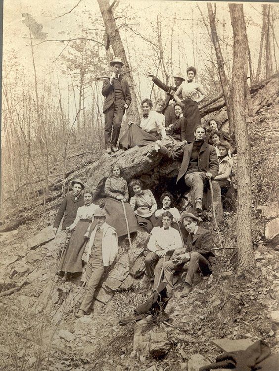 Photo of eighteen young people sitting and standing around Lewis Cave at Doubling Gap, Pa.